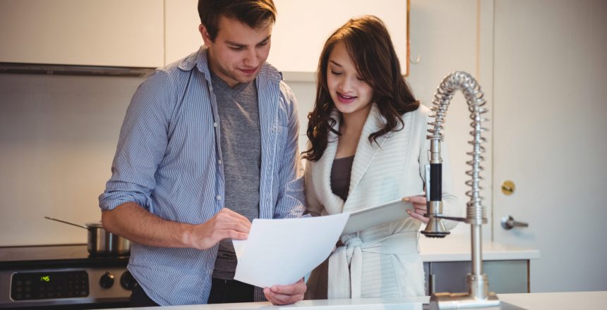 Couple discussing over digital tablet in kitchen at home