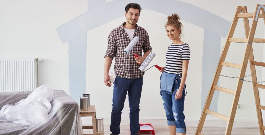 Portrait of couple painting the interior wall in new apartment